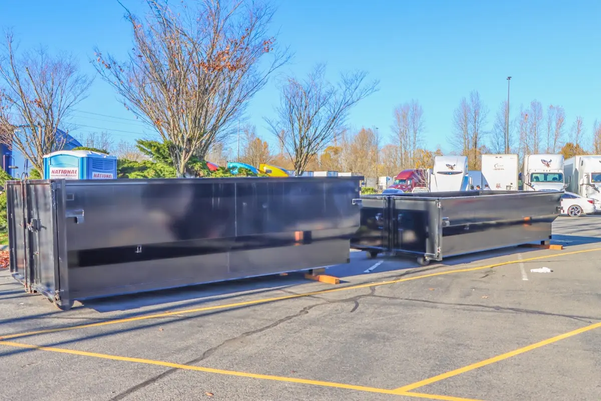 Professional dumpster rental service with roll-off container on residential driveway in Perry Heights